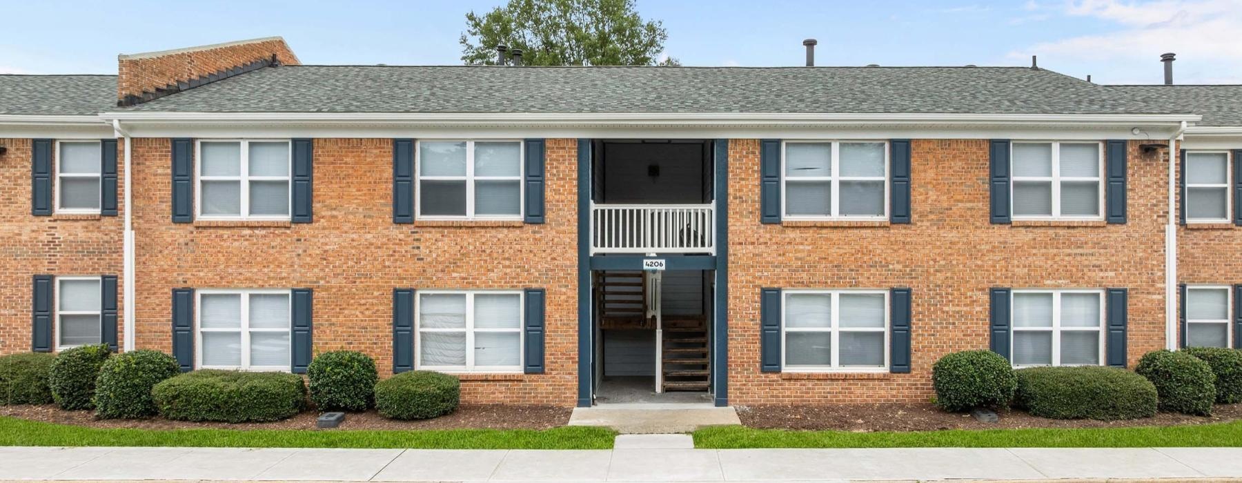 a brick building with bushes in front of it